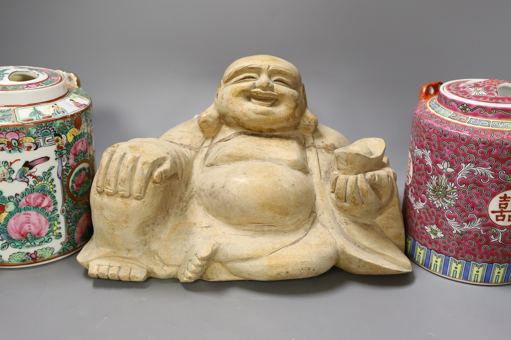 A Chinese wooden figure of Budai, two teapots in baskets and a tea caddy